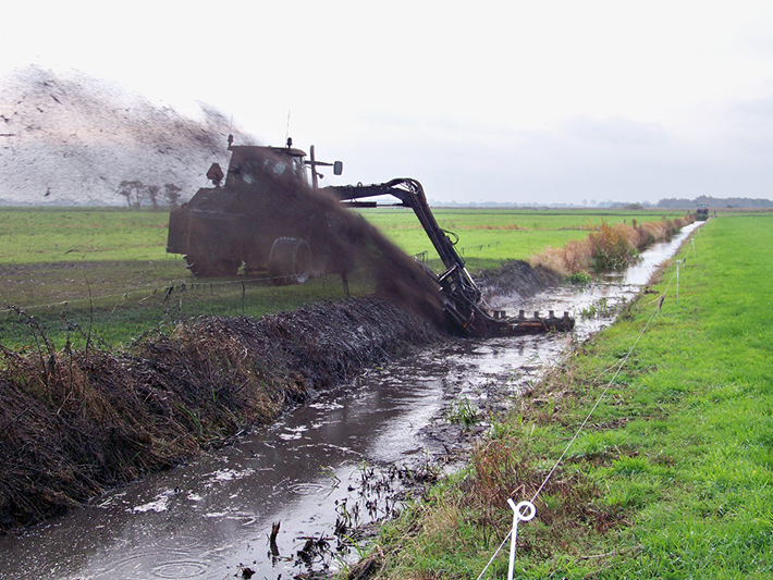 At the back of the machine the reed, mud and water is ground up and spread across the land.